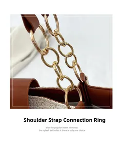 Macro shot of gold metal shoulder strap rings and brown leather trim on a woven tote