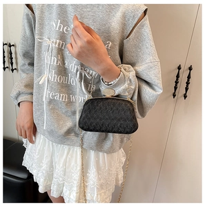 Detail of elegant black evening bag with glittering texture and gold chain strap