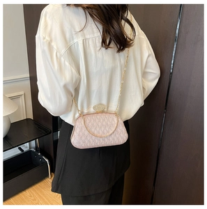 Pink sequin shell evening bag with gold chain and rhinestone clasp on a female model