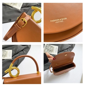 Detail of golden spiral metal handle and brown leather bag with multi-layer interior