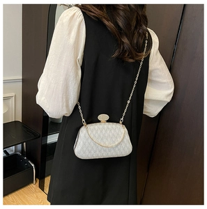 Silver glitter clutch bag with gold chain and diamond buckle shown on model shoulder
