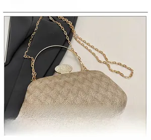 Close-up of gold chain evening bag featuring textured fabric and diamond-encrusted clasp