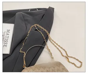Detail of elegant gold evening clutch with sparkling rhinestones and delicate metal chain
