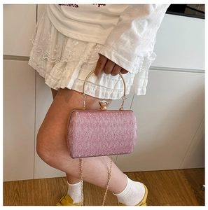 Detail of pink woven texture evening bag with round gold handle and metal chain straps
