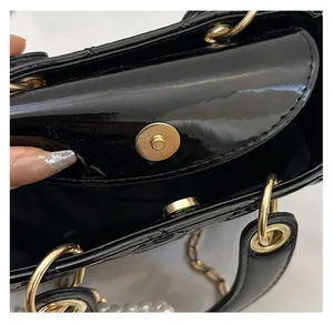 Detailed macro view of the golden magnetic buckle and quilted patent leather handbag