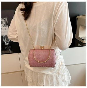 Close-up of pink glitter evening bag with crystal clasp and golden chain strap