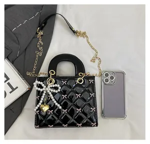 Black patent leather quilted bag with pink bow embroidery and pearl charm detail