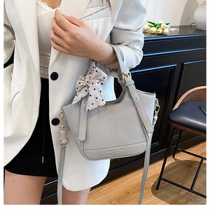 Sac seau en cuir gris clair avec nœud à pois chic et détails métalliques dorés