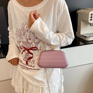 Pink glitter evening bag with gold metal handle and rhinestone clasp shown with chain strap