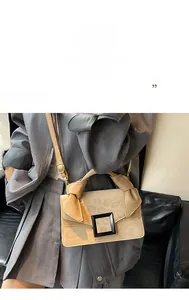 Detail of beige crossbody bag with leopard print flap and large black square buckle
