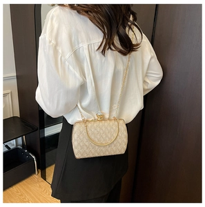 Detailed view of a gold evening bag with crystal clasp and gold metal chain strap