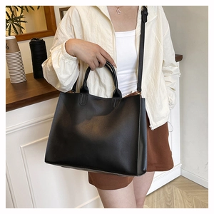 Detail view of large black tote bag with adjustable shoulder strap for office commuting