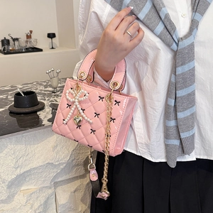 Pink patent leather quilted tote with bow patterns, pearl charm and chain strap
