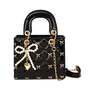 Quilted black patent leather handbag with pink bows and pearl charm on gold chain