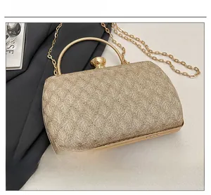 Detailed macro view of the gold glitter fabric and circular metal handle on this clutch bag