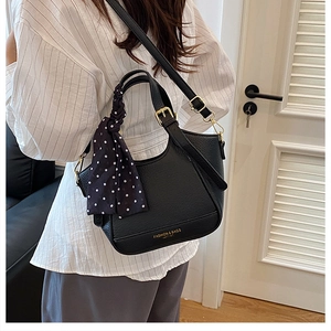 Vue détaillée du sac seau noir motif litchi avec foulard à pois et logo doré brillant
