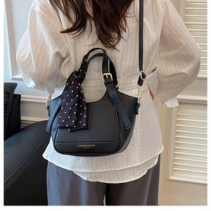 Sac seau noir en cuir grainé avec foulard en soie à pois porté en bandoulière