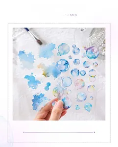 Detail shot of blue ink splashes and rainbow bubbles PET stickers on white fabric