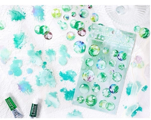 Macro detail of turquoise watercolor PET stickers with artistic paint tubes background