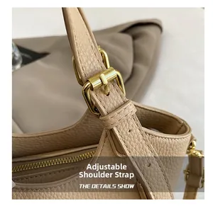 Détail d'un sac en cuir grainé beige avec bandoulière réglable à boucle dorée