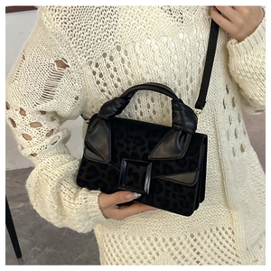 Detail of leopard print velvet handbag with large square buckle and knotted top handle