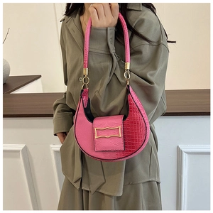 Borsa a mano rosa motivo coccodrillo con fibbia dorata mostrata dalla modella