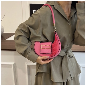 Dettaglio della borsa a mezzaluna rosa con motivo coccodrillo e fibbia in oro