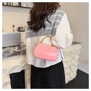 Detailed close-up of a pink glossy leather handbag with gold metal handle and chain strap