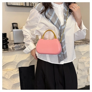 Pink glossy mini box bag with golden bamboo handle and delicate metal chain strap