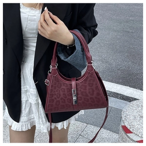 Detail of burgundy leopard print bucket bag with silver buckle and thin shoulder strap
