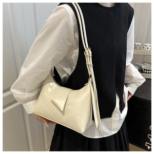 Close-up of a cream-colored minimalist underarm bag with adjustable shoulder strap detail
