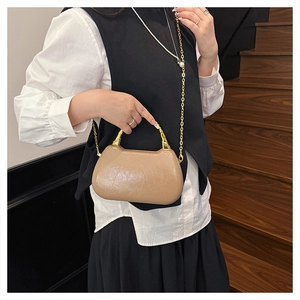 Detail of trendy khaki box bag with gold bamboo handle and chic cracked leather texture