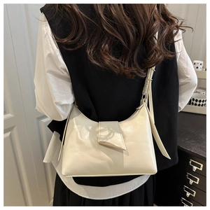 Detailed view of beige faux leather shoulder bag with metallic trim on triangle flap