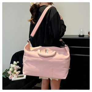 Pink travel bag detail featuring adjustable shoulder strap and durable metal buckle