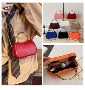 Detailed view of colors and compact interior of a mini box bag with gold metal handle
