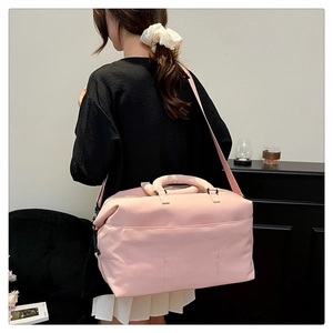 Pink travel duffel bag with detachable shoulder strap and large side pockets