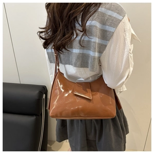 Detail of vintage brown glossy leather hobo bag showing texture and metal buckle