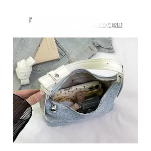 Detail view of denim hobo bag interior showing storage space for phone and makeup
