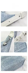 Detail of light blue denim bag with silver studs and heart-shaped zipper puller