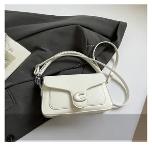Detail shot of the white woven texture and metallic C buckle on the crossbody handbag