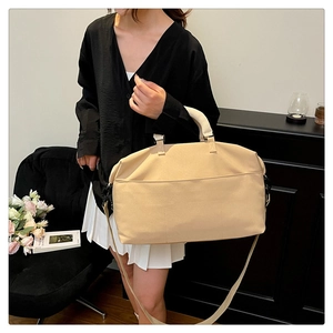Detail view of large khaki travel bag with front pocket and adjustable shoulder straps