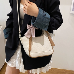 Sac seau blanc chic avec bordure marron et foulard en soie sur un mannequin