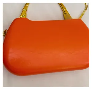 Detailed macro view of orange faux leather texture and gold bamboo-style handle
