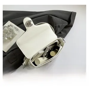 Internal view of white leather crossbody bag with spacious compartments and a zipper pocket