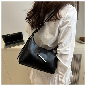 Detailed shot of a black PU leather hobo bag with a silver buckle and adjustable strap