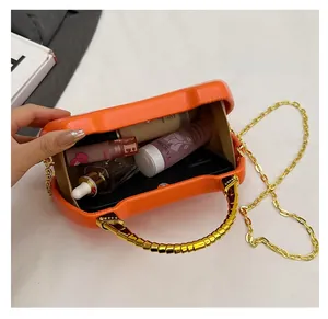 Top view of orange box bag showing spacious interior with smartphone and cosmetics