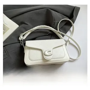 Detailed view of white quilted handbag featuring a gold metallic C-logo and woven handle