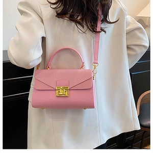 Vista dettagliata della borsa rosa con patta a trama a rombi e chiusura in metallo dorato