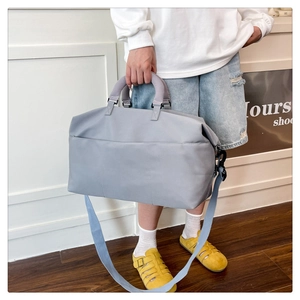 Close-up of gray-blue travel bag featuring high-density nylon and reinforced hand straps