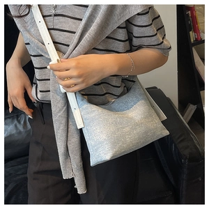 Detail of light blue denim hobo bag with silver glitter and white leather shoulder strap